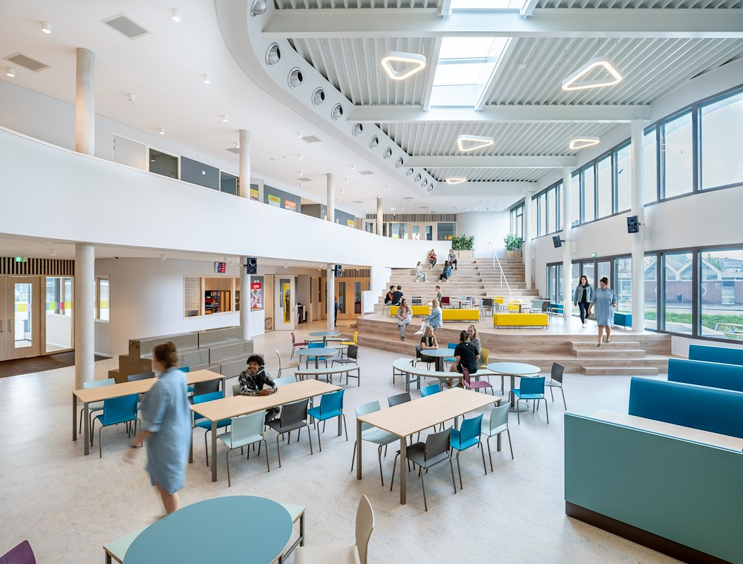 Lichte onderwijsomgeving met studieplekken en een centrale ontmoetingsruimte